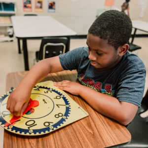 kid in classroom with clock
